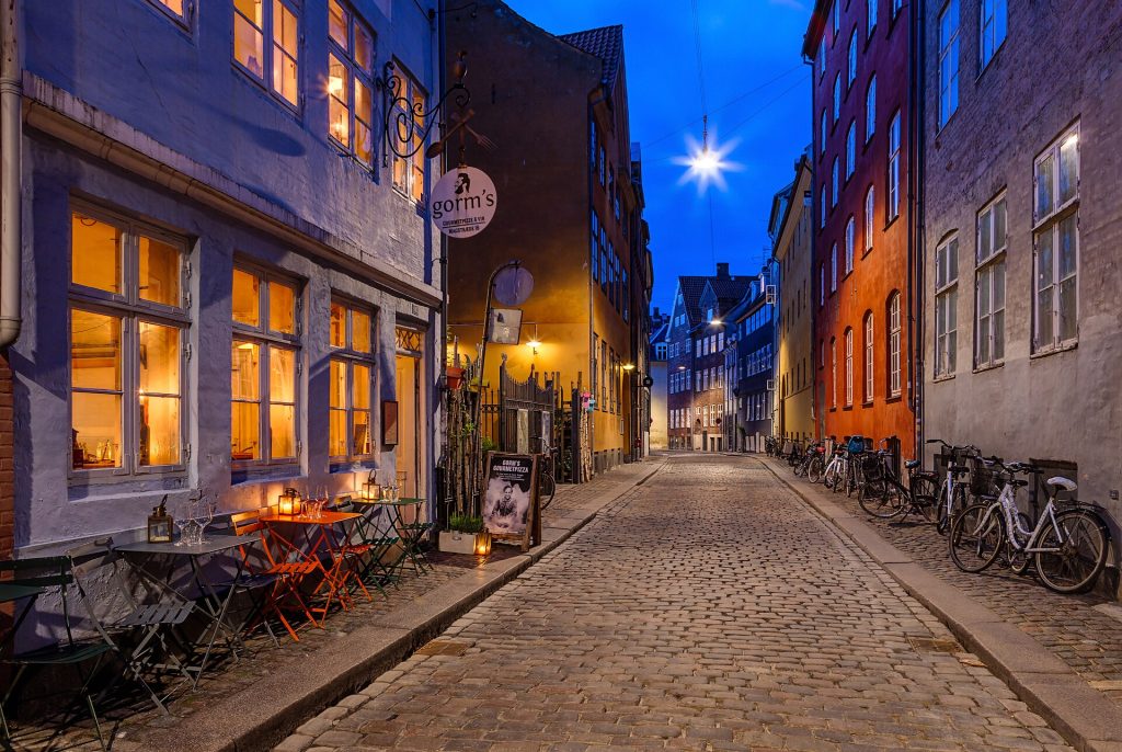 Magstræde i København om aftenen med brosten og oplyste vinduer
